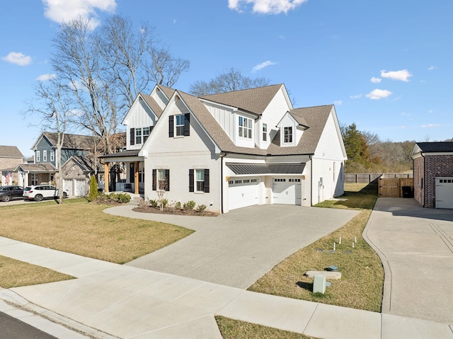 modern farmhouse featuring fence, driveway, roof with shingles, a front lawn, and board and batten siding