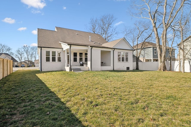 back of property featuring a yard, fence, and brick siding