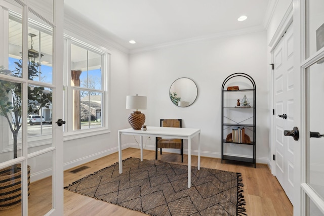 office space with baseboards, wood finished floors, visible vents, and ornamental molding