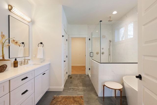 bathroom featuring vanity, a freestanding tub, baseboards, and a stall shower