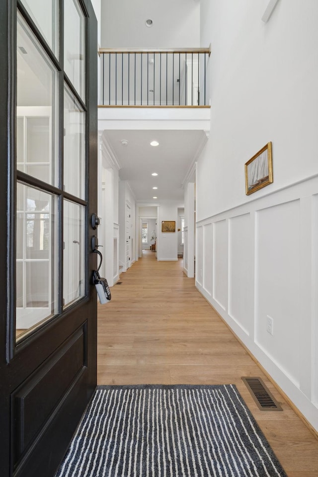 foyer with visible vents, recessed lighting, a decorative wall, and wood finished floors