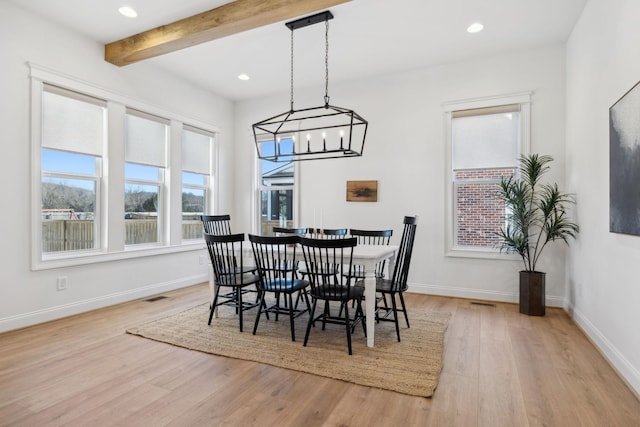 dining area with light wood finished floors, visible vents, beam ceiling, and baseboards