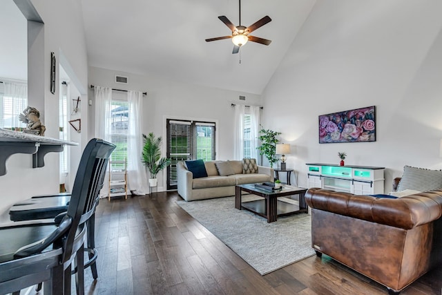 living area featuring dark wood finished floors, ceiling fan, visible vents, and high vaulted ceiling