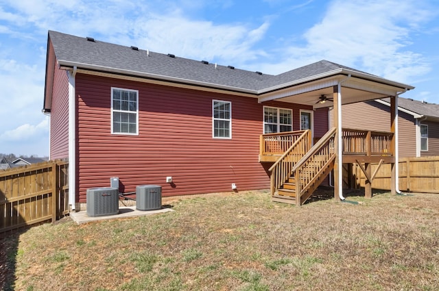 back of house featuring stairs, central AC unit, fence, and a lawn