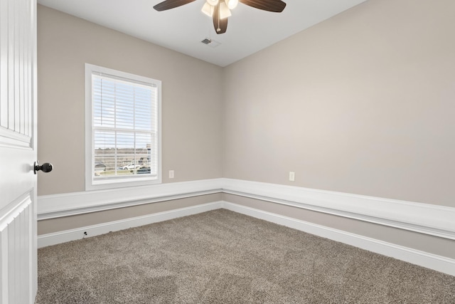 carpeted empty room with visible vents, baseboards, and ceiling fan