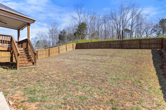 view of yard featuring a wooden deck, a fenced backyard, and stairs