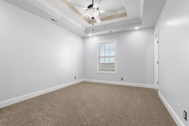 unfurnished room with ornamental molding, a ceiling fan, a tray ceiling, carpet, and baseboards