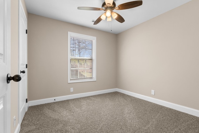 carpeted spare room featuring baseboards and a ceiling fan