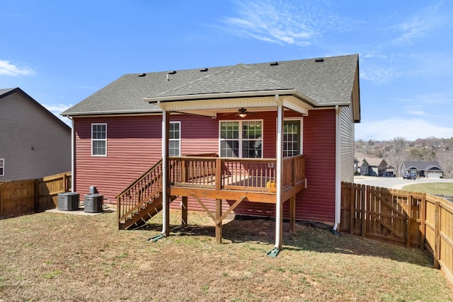 back of house with a lawn, roof with shingles, a fenced backyard, and a ceiling fan