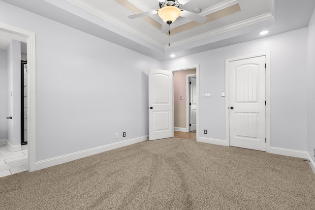 unfurnished bedroom featuring a tray ceiling, recessed lighting, carpet, crown molding, and baseboards