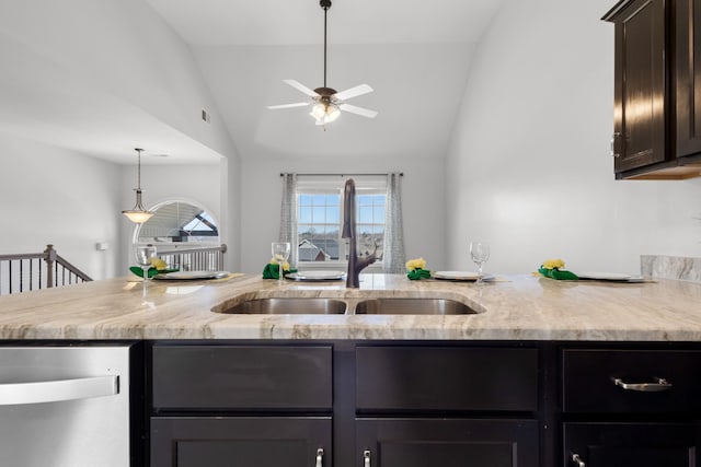 kitchen with a sink, light stone countertops, vaulted ceiling, and hanging light fixtures