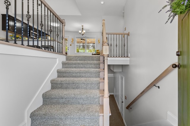 stairway with a notable chandelier