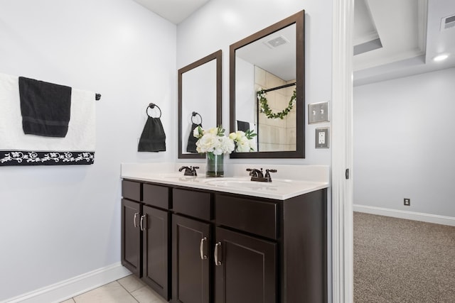 bathroom featuring double vanity, baseboards, visible vents, and a sink