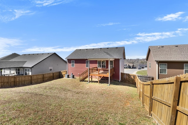 rear view of house featuring stairs, a lawn, a fenced backyard, and a wooden deck