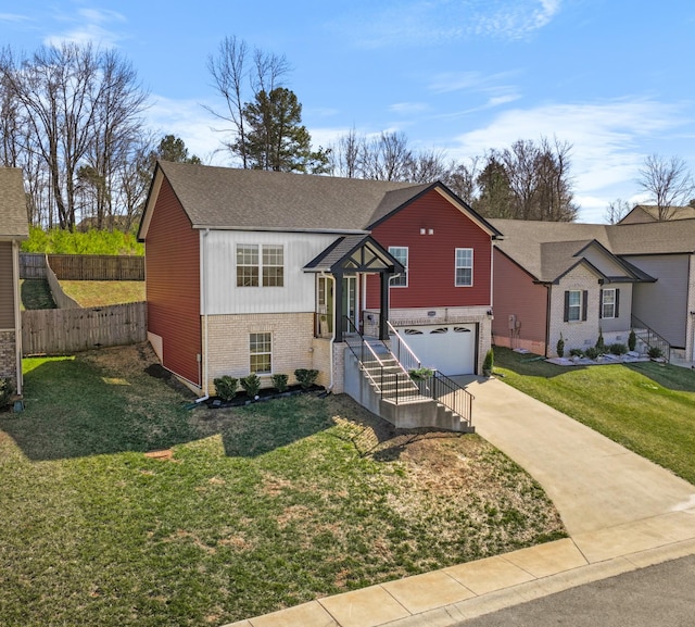 bi-level home featuring fence, concrete driveway, a front lawn, a garage, and brick siding