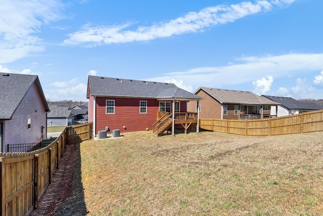 rear view of house with cooling unit, a wooden deck, a yard, a fenced backyard, and a residential view