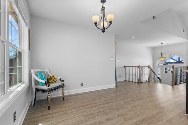 sitting room featuring wood finished floors, baseboards, an upstairs landing, and a chandelier