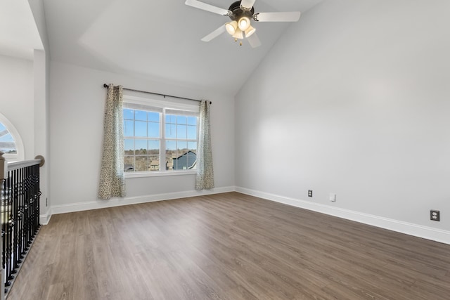 empty room with baseboards, wood finished floors, a ceiling fan, and vaulted ceiling