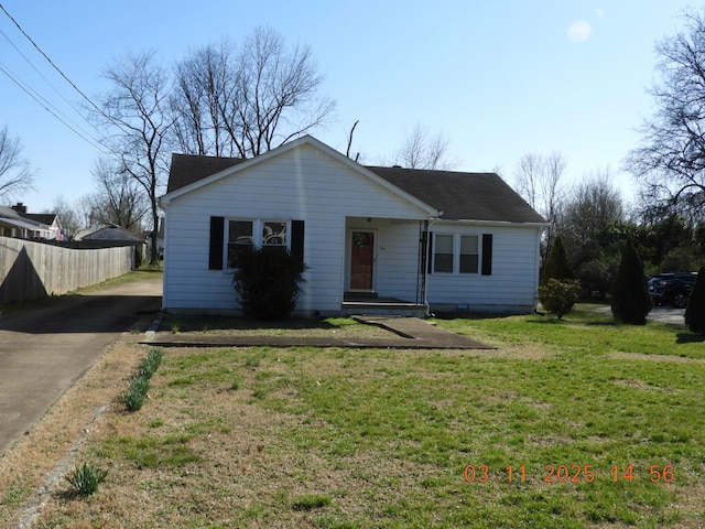 view of front of property featuring driveway, a front lawn, and fence