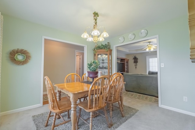 dining space featuring baseboards, carpet flooring, and ceiling fan with notable chandelier