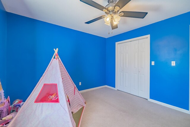 recreation room with a ceiling fan, baseboards, and carpet floors