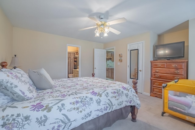 bedroom with light colored carpet, a ceiling fan, and connected bathroom