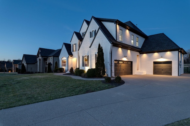 view of front facade featuring a front yard, brick siding, and driveway