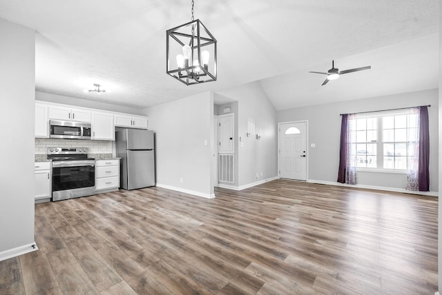 3441 Foxrun Ln, Clarksville, TN 37042 - kitchen with open floor plan, decorative backsplash, wood finished floors, white cabinets, and stainless steel appliances
