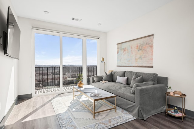 living area featuring visible vents, baseboards, and wood finished floors