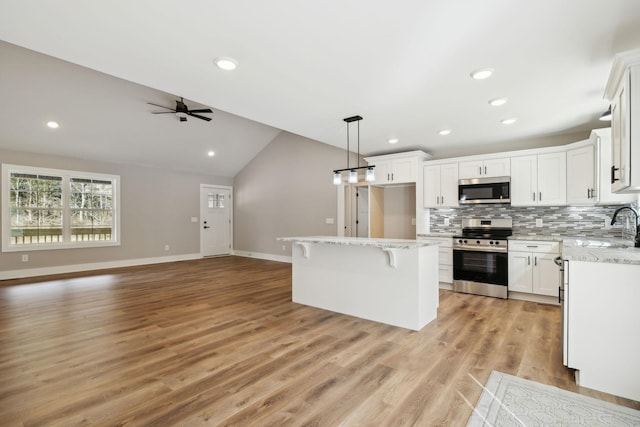 1507 New Harmony Rd, Hartsville, TN 37074 - kitchen with appliances with stainless steel finishes, open floor plan, lofted ceiling, backsplash, and white cabinets