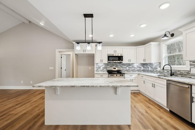 1507 New Harmony Rd, Hartsville, TN 37074 - kitchen with stainless steel appliances, a sink, decorative backsplash, white cabinetry, and lofted ceiling
