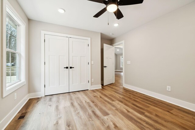 1507 New Harmony Rd, Hartsville, TN 37074 - unfurnished bedroom featuring light wood-style flooring, baseboards, multiple windows, recessed lighting, and a closet