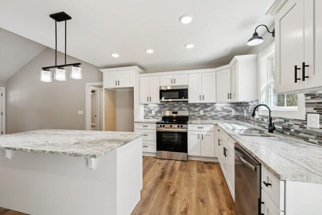 1507 New Harmony Rd, Hartsville, TN 37074 - kitchen with appliances with stainless steel finishes, a sink, white cabinetry, backsplash, and light wood finished floors