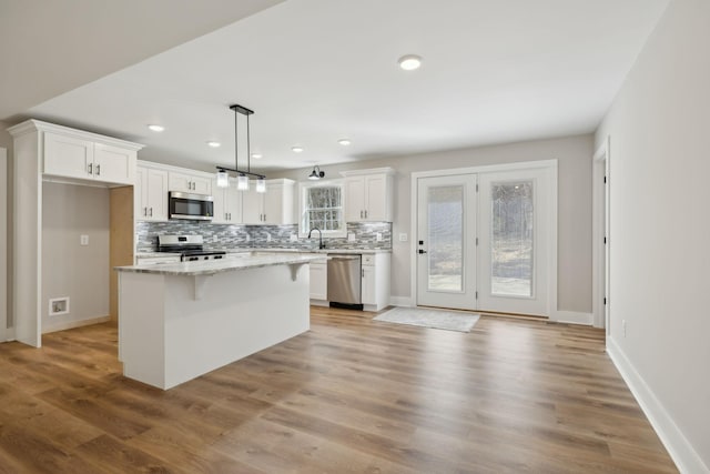 1507 New Harmony Rd, Hartsville, TN 37074 - kitchen featuring stainless steel appliances, backsplash, white cabinetry, recessed lighting, and a kitchen island