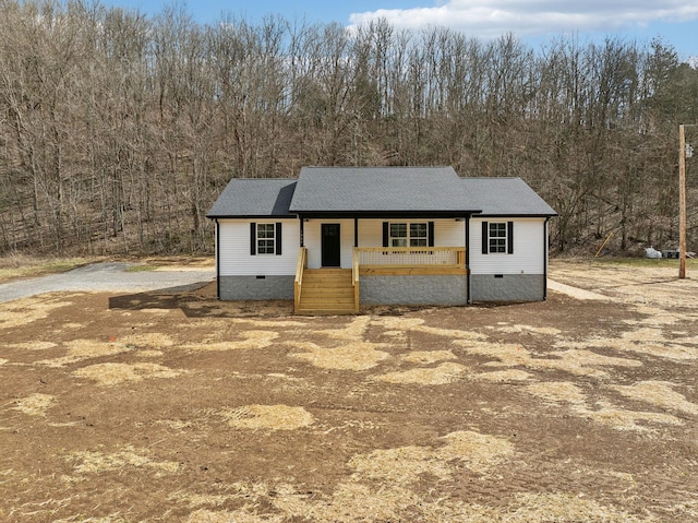 view of front facade featuring crawl space, a porch, and a shingled roof