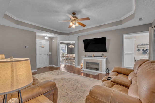 living room featuring a textured ceiling, a raised ceiling, and wood finished floors