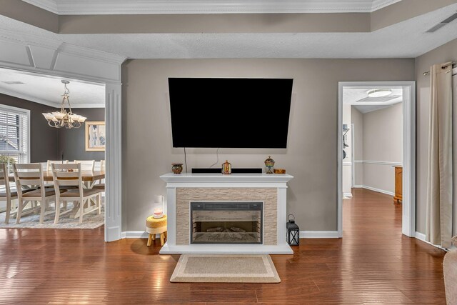 living room with a glass covered fireplace, wood finished floors, visible vents, and baseboards