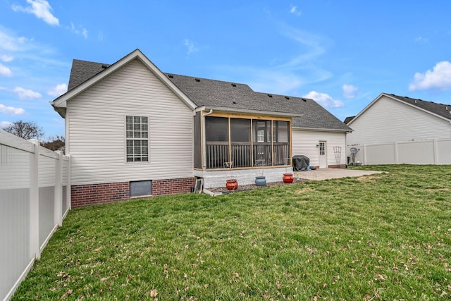 back of property with a yard, a patio area, a fenced backyard, and a sunroom