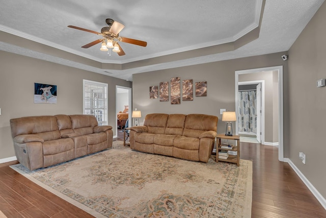 living room featuring dark wood-type flooring, baseboards, and a textured ceiling