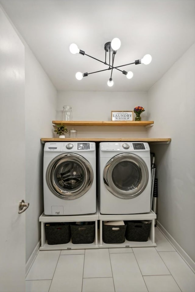 laundry room featuring baseboards, laundry area, washer and dryer, tile patterned floors, and a notable chandelier