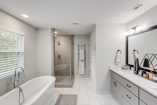 bathroom featuring visible vents, a shower stall, a freestanding bath, and vanity