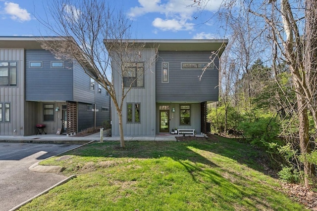 rear view of property with a lawn and board and batten siding