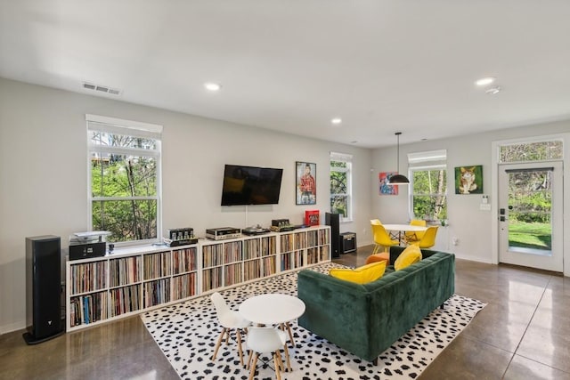 living room with a wealth of natural light, visible vents, recessed lighting, and baseboards