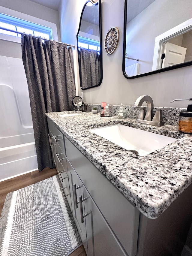 bathroom featuring vanity, wood finished floors, and shower / tub combo with curtain