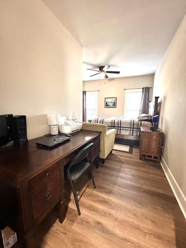 living area with a ceiling fan, light wood-style floors, and baseboards