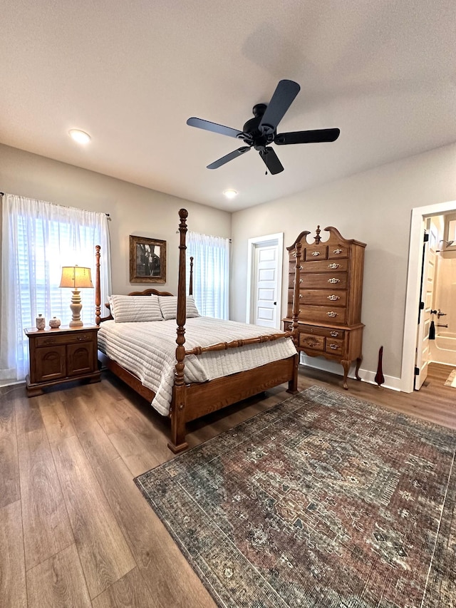 bedroom featuring multiple windows, a ceiling fan, and wood finished floors