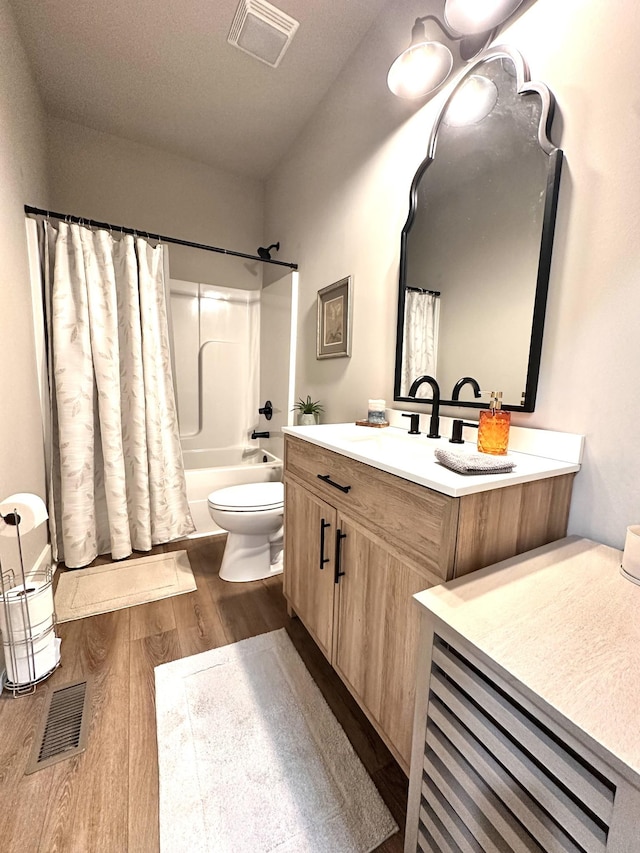 bathroom with visible vents, toilet, wood finished floors, and vanity