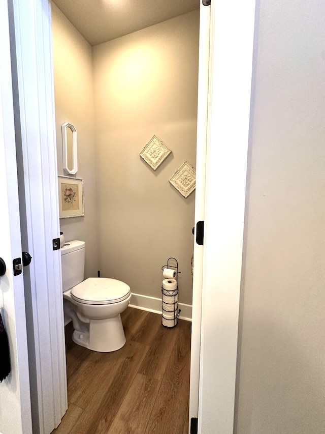 bathroom featuring baseboards, toilet, and wood finished floors