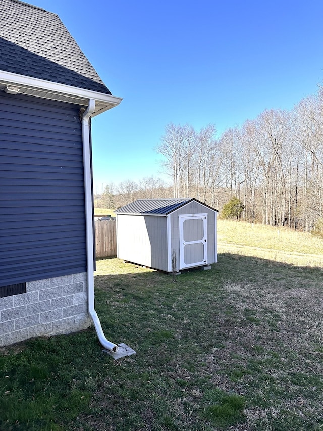 view of yard with a storage shed, fence, and an outdoor structure