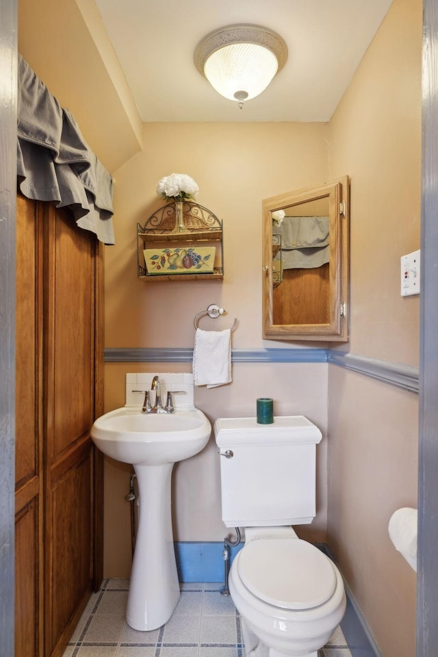 bathroom featuring toilet and baseboards